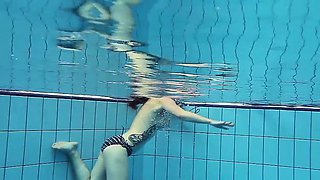 Redheaded cutie swimming nude in the pool