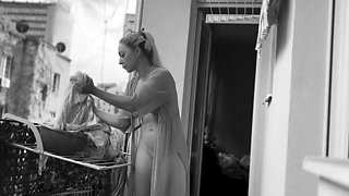 Naked chubby woman hangs out laundry on the balcony for
