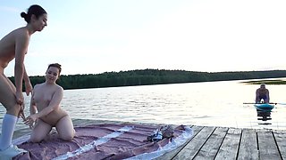 Slim teens were laying naked by the lake and lucky guy ended up in threesome