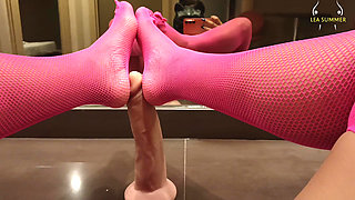 A milf with a large vagina masturbates with her dildo using her feet, then inserts a black dildo.